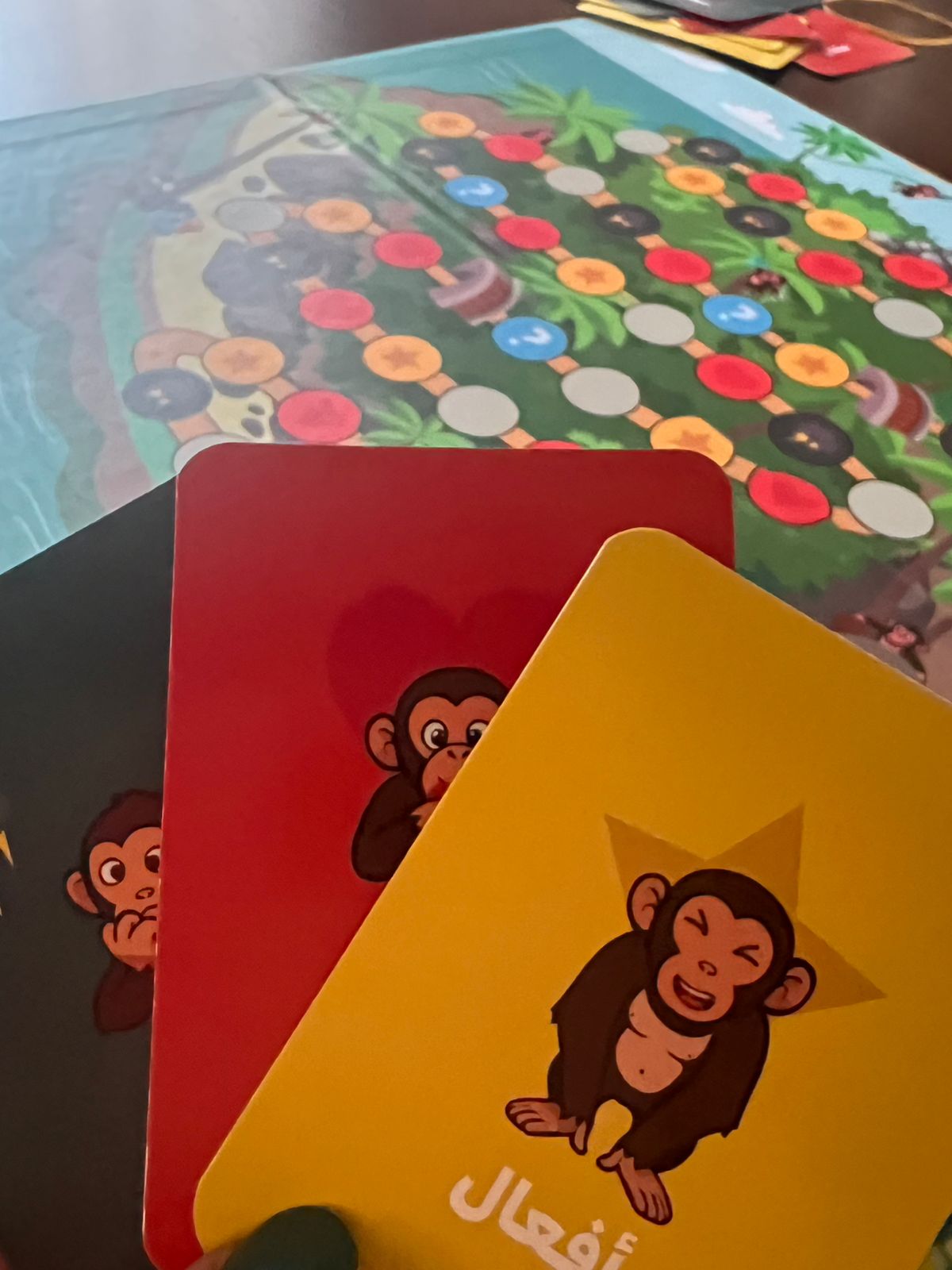 Two card with monkey illustrations on a colorful board game background